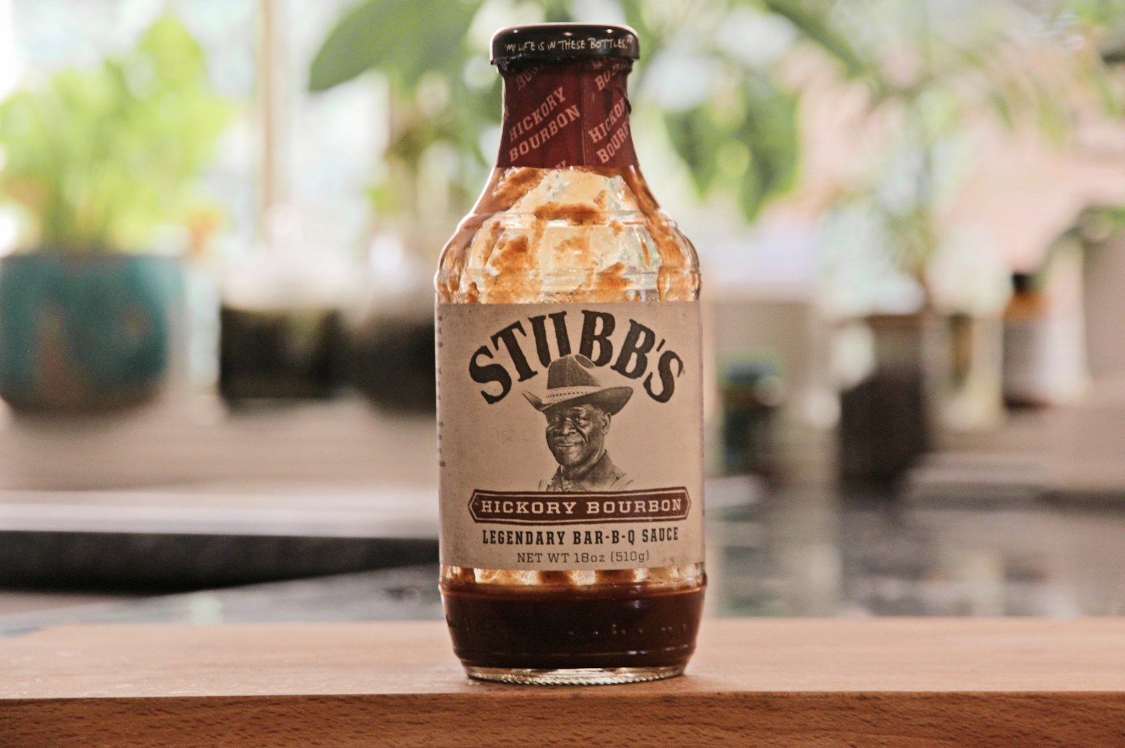 une bouteille de sauce piquante posée sur une table en bois